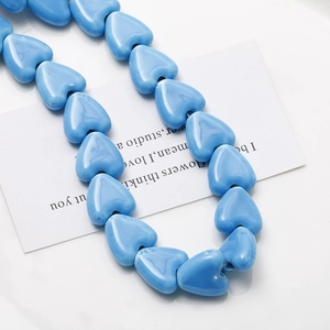 Vue détaillée de perles en céramique bleu ciel en forme de cœur avec glaçure brillante
