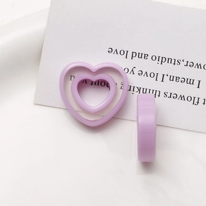 Detailed view of lavender heart resin charms for DIY jewelry on a white card background