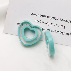 Macro shot of light blue heart resin charm with double-layered hollow design for jewelry DIY