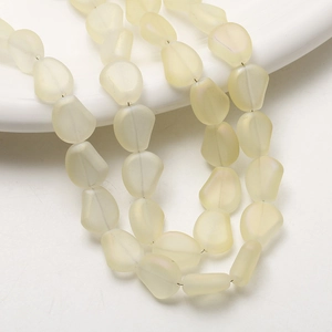 Détail de perles irrégulières en verre jaune mat avec une texture givrée pour bijoux DIY