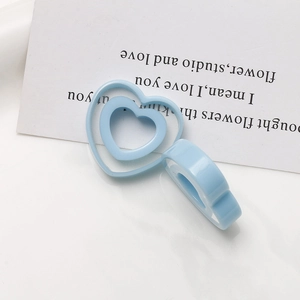 Detail of baby blue resin heart-shaped jewelry charms with hollow-out nested design