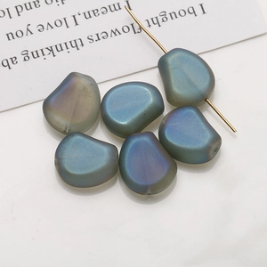 Vue détaillée de perles en verre irisées bleu-vert irrégulières pour bijoux DIY