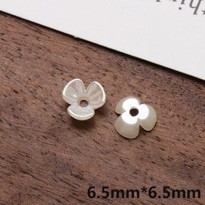 Macro detail of 6.5mm iridescent pearl white five-petal flower acrylic beads for DIY jewelry