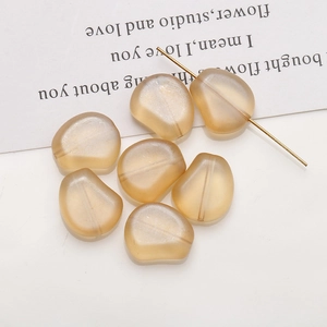 Détail de perles en verre givré ambre avec trou central pour la création de bijoux