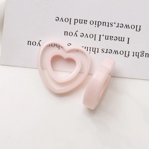 Close-up of pastel pink resin heart rings with hollow design for DIY jewelry