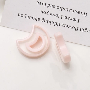 Macro detail of light pink moon-shaped resin charms for DIY earring jewelry making