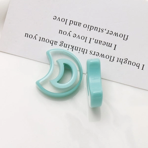 Macro view of mint green resin crescent moon charms for DIY earrings and jewelry making