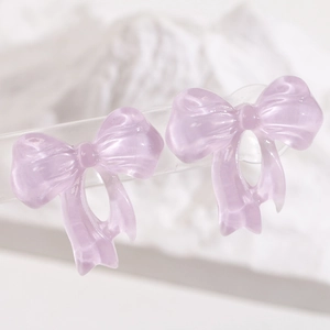 Macro detail of lavender translucent resin bow earrings with elegant pearlescent finish