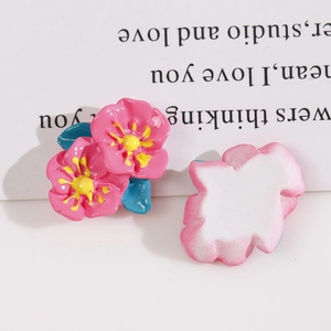 Macro view showing the glossy pink resin flower charms and their flat white back for DIY