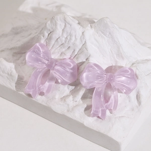 Close-up of translucent light purple resin butterfly bow pendants for DIY jewelry making