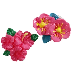 Pink hibiscus resin hair clip featuring vibrant yellow stamens and green tropical leaves
