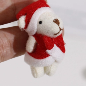 Close-up of a mini Christmas plush bear pendant with red bow and festive holiday hat