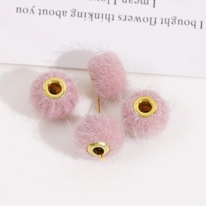 Detailansicht von vier rosa Plüschkugeln mit goldenen Metallösen für DIY-Schmuckherstellung