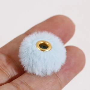 Close-up van een lichtblauwe pluche kraal van 20 mm met een gouden gat voor DIY-sieraden