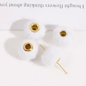 Detailansicht weißer Plüschperlen mit goldenen Metalllöchern für DIY-Schmuckherstellung