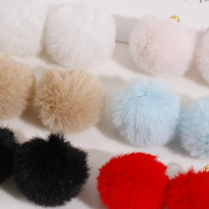 Close-up of colorful 20mm soft plush faux fur balls with gold loops for DIY jewelry