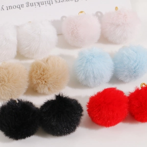 Macro detail of 20mm soft colorful faux fur pompom charms with golden loops for DIY jewelry