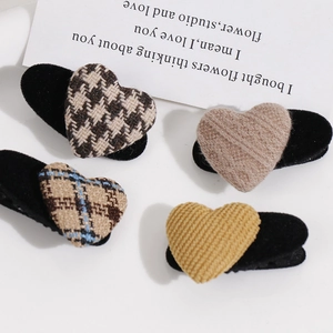 Detalle de pinzas para el cabello de corazón con estampados de cuadros y punto