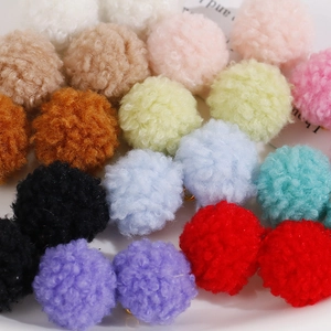 Gros plan de pompons en peluche colorés avec anneaux métalliques pour création de bijoux