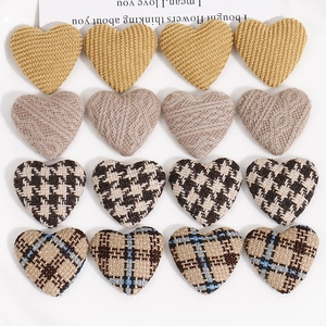 Vista plana de parches de tela en forma de corazón con cuadros y punto para accesorios DIY