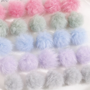 Macro detail of soft pastel faux fur pom poms for DIY jewelry in various colors
