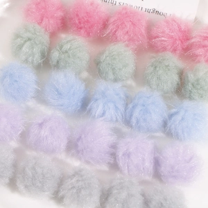 Close-up of pastel plush pom-poms with glitter fibers for DIY jewelry and accessories