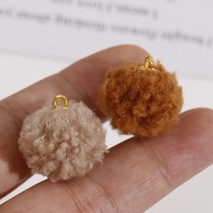 Détail macro de breloques en peluche beige et marron avec boucles dorées pour bijoux DIY