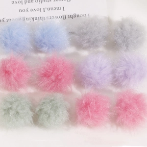 Flat lay of soft 12-piece colorful faux fur pompom balls for DIY jewelry and crafts