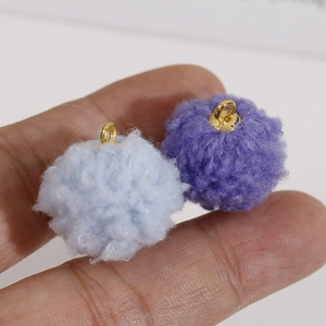 Gros plan de pompons en peluche bleu et violet avec anneaux dorés pour accessoires bijoux DIY