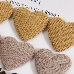Primer plano macro de botones de tela tejida en forma de corazón con textura de canalé