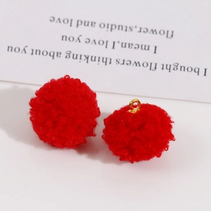 Vue macro de pendentifs pompons rouges duveteux avec boucle dorée et texture douce