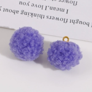 Vue détaillée de pompons en peluche violets avec anneaux dorés pour la création de bijoux DIY
