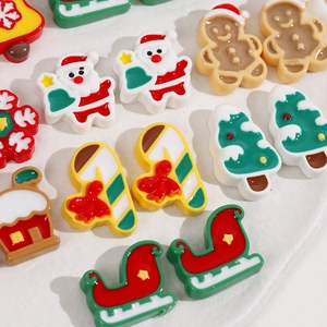 Macro shot of colorful resin Christmas charms including Santa and gingerbread man for DIY crafts