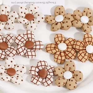 Detalle de flores de tela de cinco pétalos con estampados de lunares y cuadros para DIY