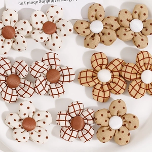 Accesorios de flores de tela con patrones de cuadros y lunares en tonos tierra