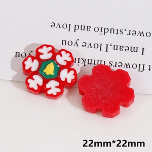 Macro detail of 22mm Christmas red flower resin charm with snowflake and bell patterns
