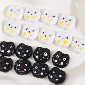 Close-up of cute acrylic cat head beads in black and white for DIY jewelry making