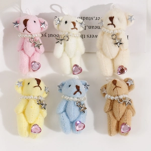 Detail view of colorful plush bear charms with pearls, star pendants and heart gemstones