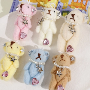 Close-up of mini plush bears with pearl necklaces and heart rhinestones in six colors