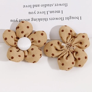 Detalle de flores de tela con lunares marrones y botones blancos para accesorios DIY