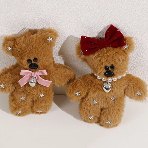 Detailed view of plush brown bear keychains with velvet bows and sparkling silver stars