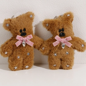 Detail of plush brown teddy bear charms featuring pink velvet bows and silver star sequins