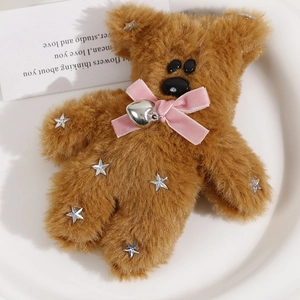 Detail of plush brown bear pendant with pink velvet bow, silver heart and star sequins