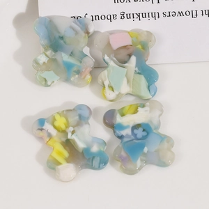 Dettaglio di ciondoli a forma di orso in resina acetata con motivo marmorizzato DIY