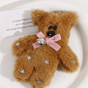Detail of plush brown bear pendant with pink velvet bow and silver star sequins