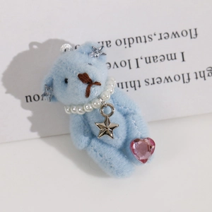 Detail of light blue plush bear keychain with pearl necklace and star charm