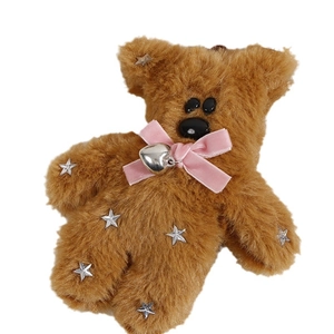 Brown plush bear doll with pink velvet bow and silver star accents on white background