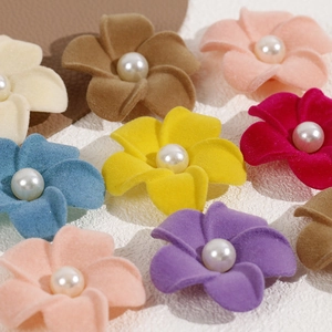Macro detail of flocked 5-petal flower charms with central pearl in Morandi colors