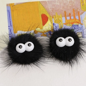 Pair of fuzzy black soot sprites with big round eyes on a colorful illustrated backdrop