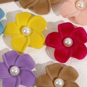 Macro shot of flocked velvet five-petal flower charms with central pearl in assorted colors
